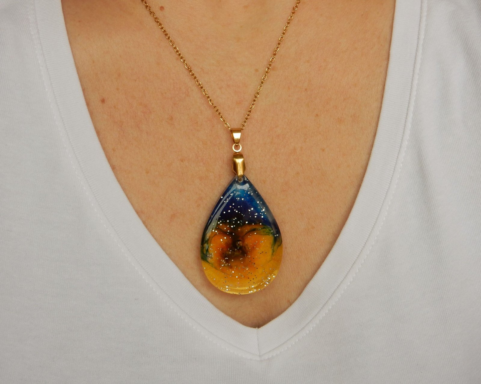 Colgante hecho con RESINA EPOXI y duo de TINTAS AMARILLA Y AZUL.encapsulada en resina. Cadena de acero inoxidable.