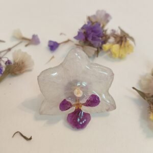 Anillo con base ajustable y de acero inoxidable con UNA ORQUÍDEA REAL encapsulada en resina.