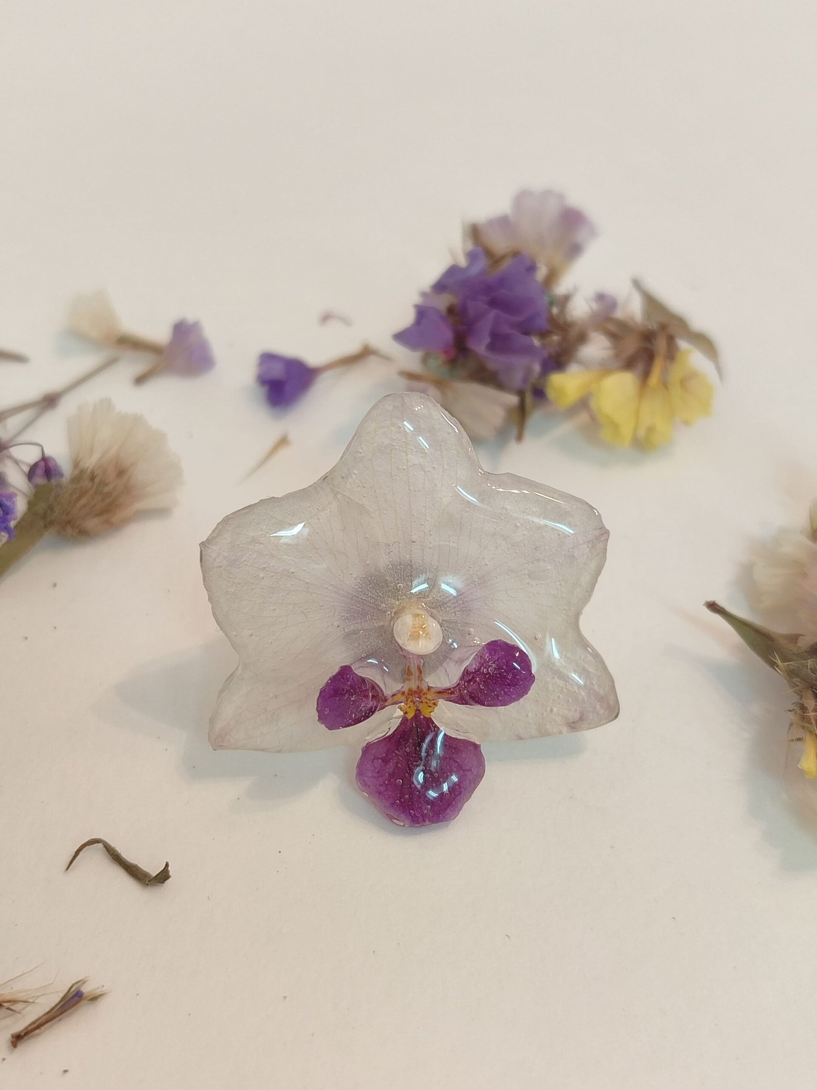 Anillo con base ajustable y de acero inoxidable con UNA ORQUÍDEA REAL encapsulada en resina.