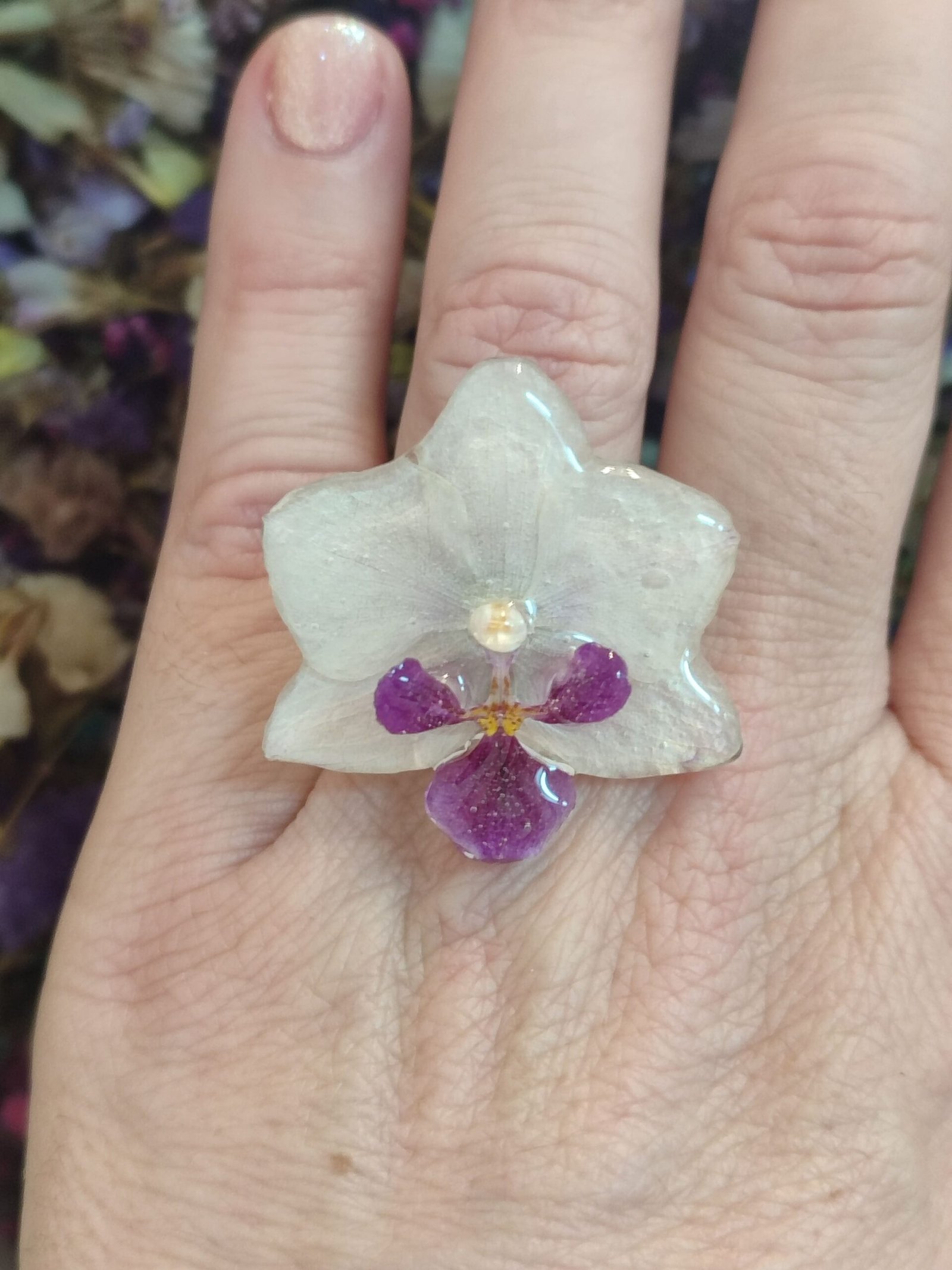 Anillo con base ajustable y de acero inoxidable con UNA ORQUÍDEA REAL encapsulada en resina.