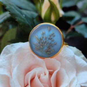 Anillo con base ajustable DORADA con UNAS HOJAS SILVESTRES encapsuladas en resina.