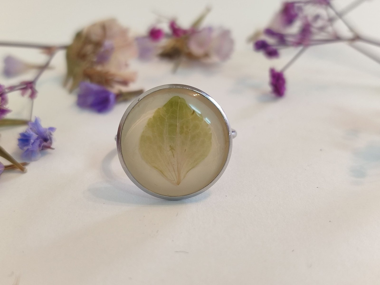 Anillo con base ajustable con UNA FLOR DE HORTENSIA encapsulada en resina.