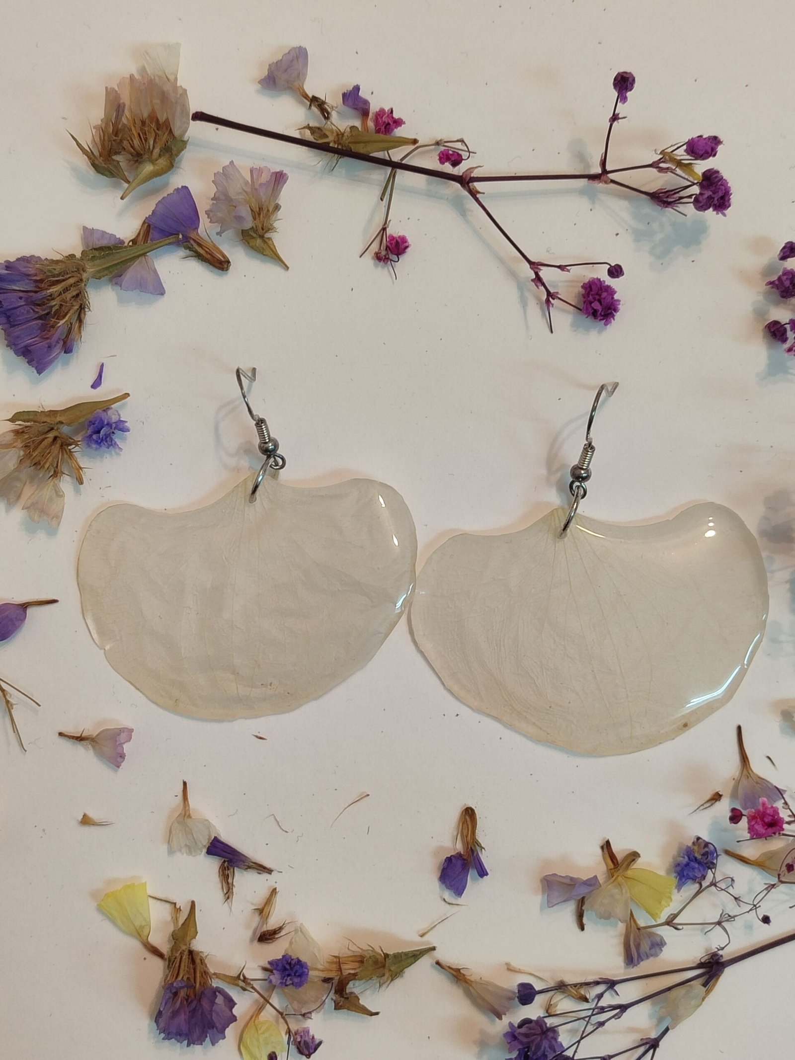 Pendientes con UNOS PÉTALOS DE ORQUÍDEA BLANCA encapsulados en resina.