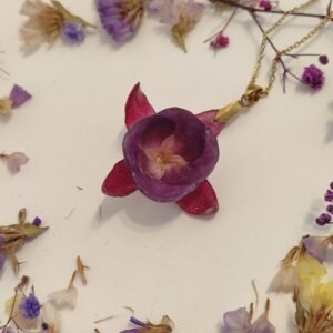 Colgante con UNA FLOR DE PENDIENTES DE LA REINA encapsulada en resina.