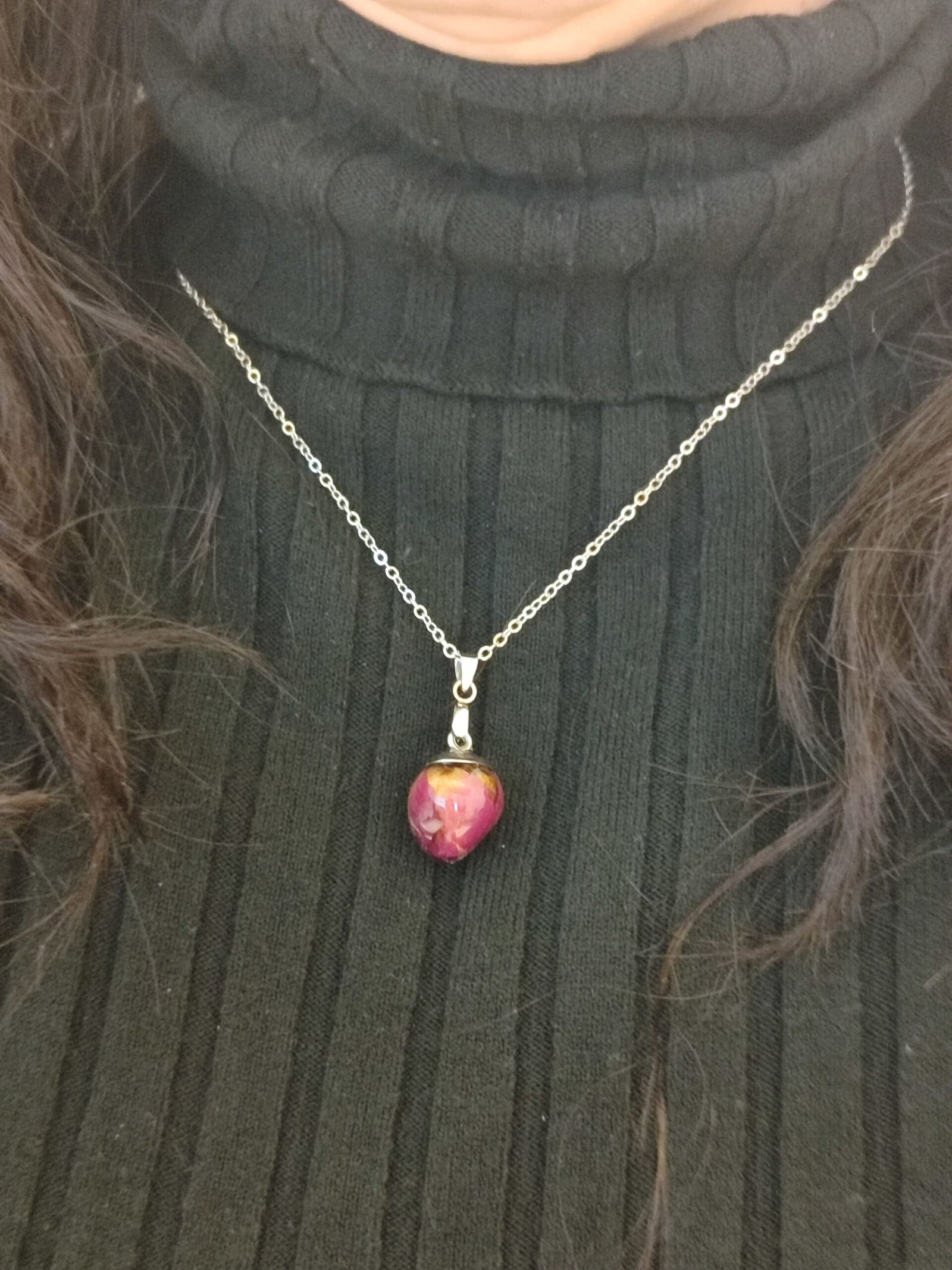 Colgante con UN CAPULLO DE ROSA encapsulado en resina.