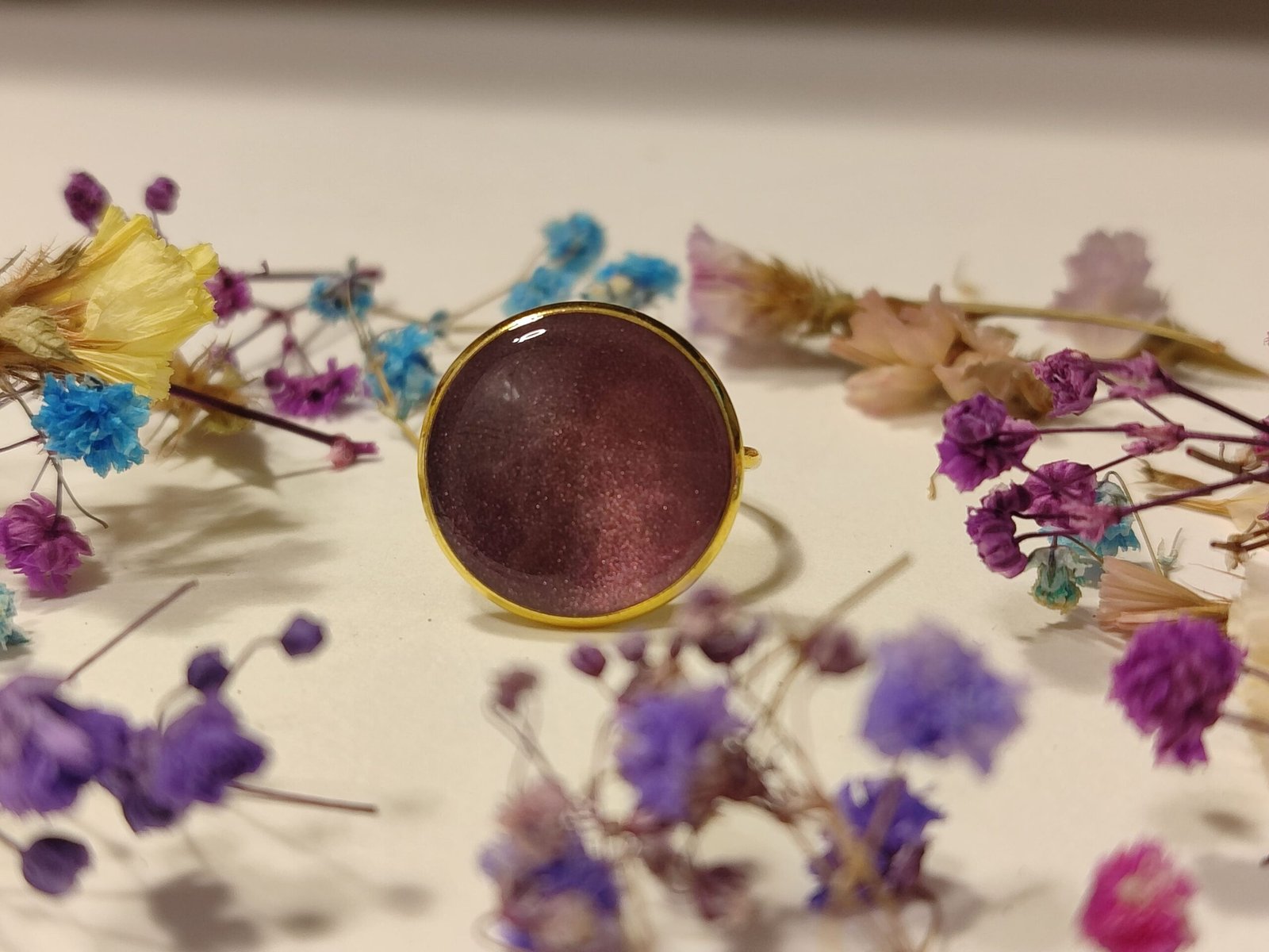 Anillo ajustable de acero inoxidable con POLVO IRIDISCENTE encapsulado en resina.