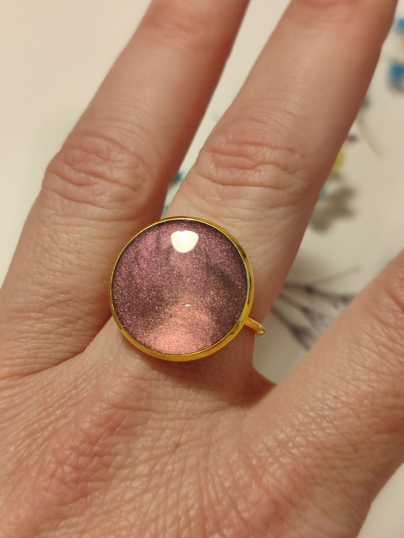 Anillo ajustable de acero inoxidable con POLVO IRIDISCENTE encapsulado en resina.