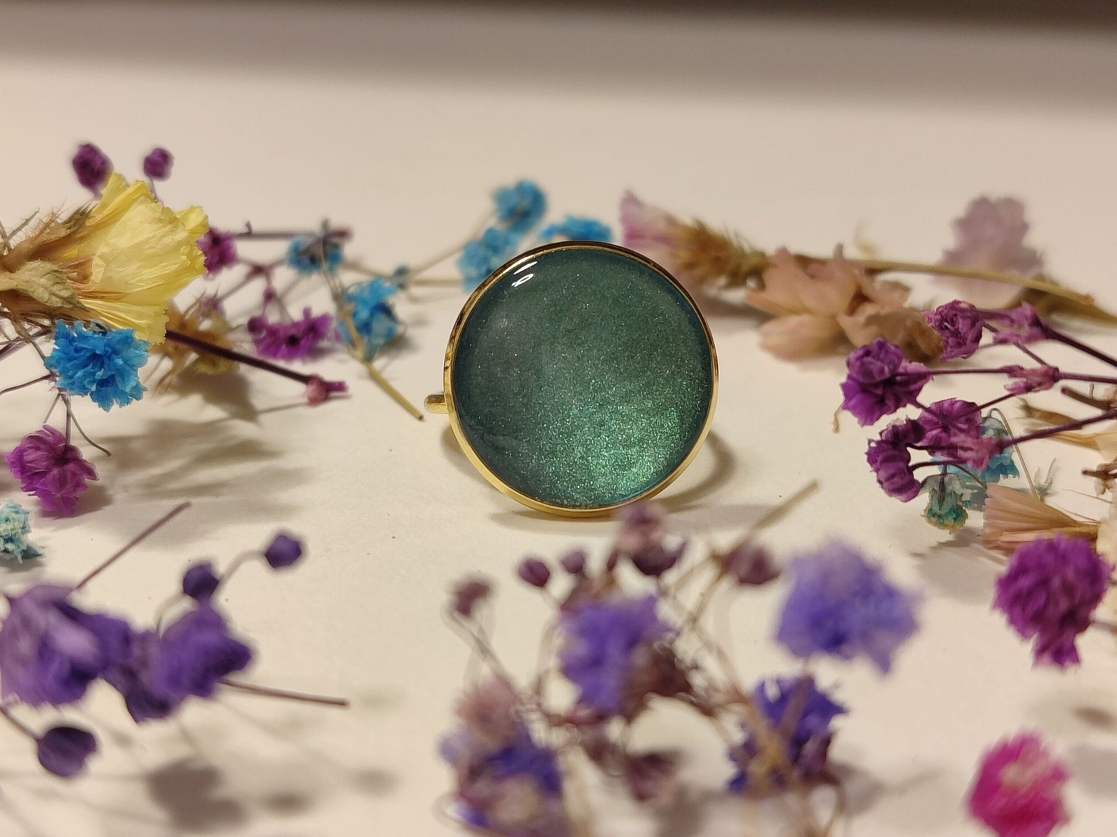 Anillo ajustable de acero inoxidable con POLVO IRIDISCENTE encapsulado en resina.