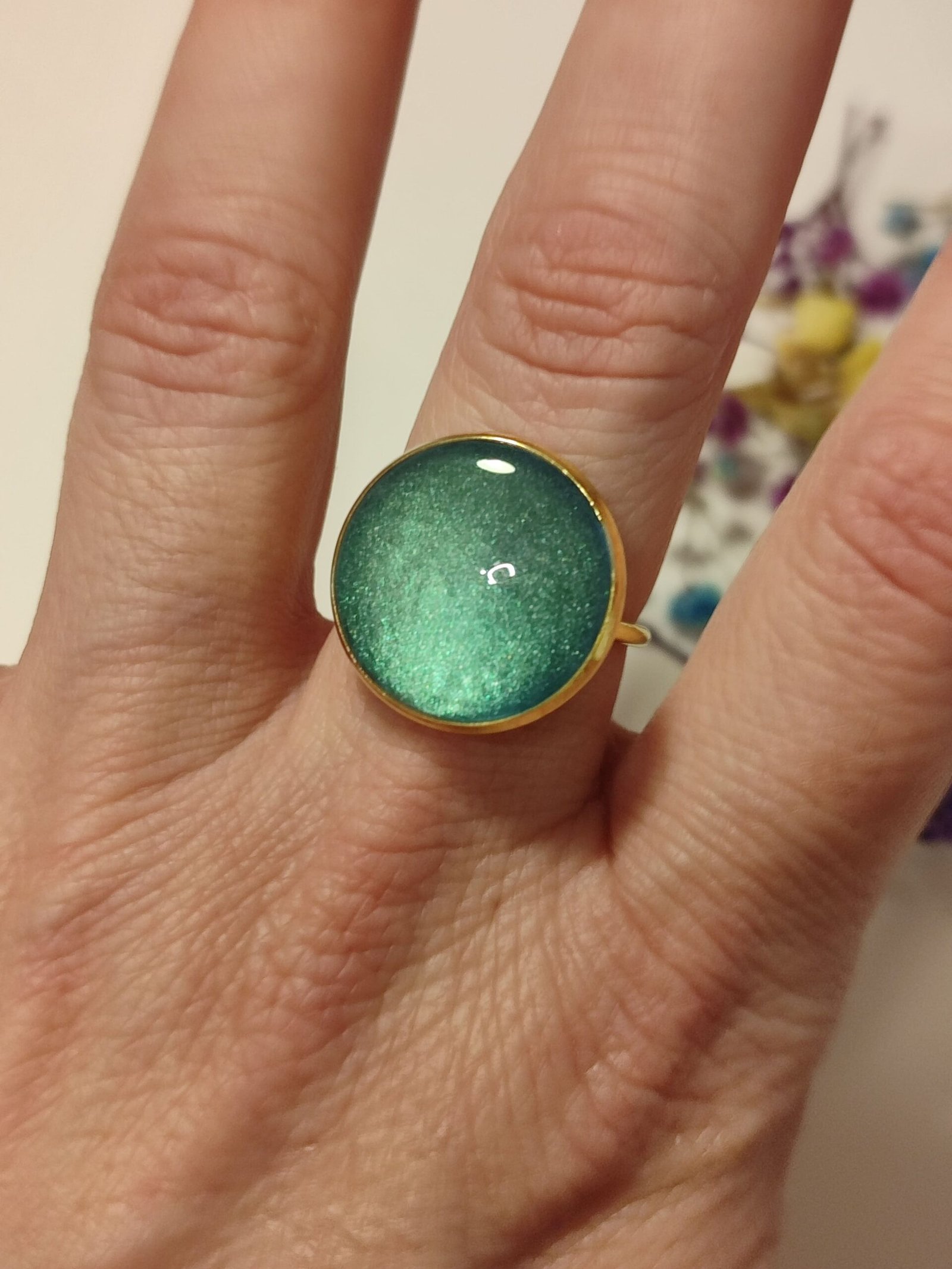 Anillo ajustable de acero inoxidable con POLVO IRIDISCENTE encapsulado en resina.