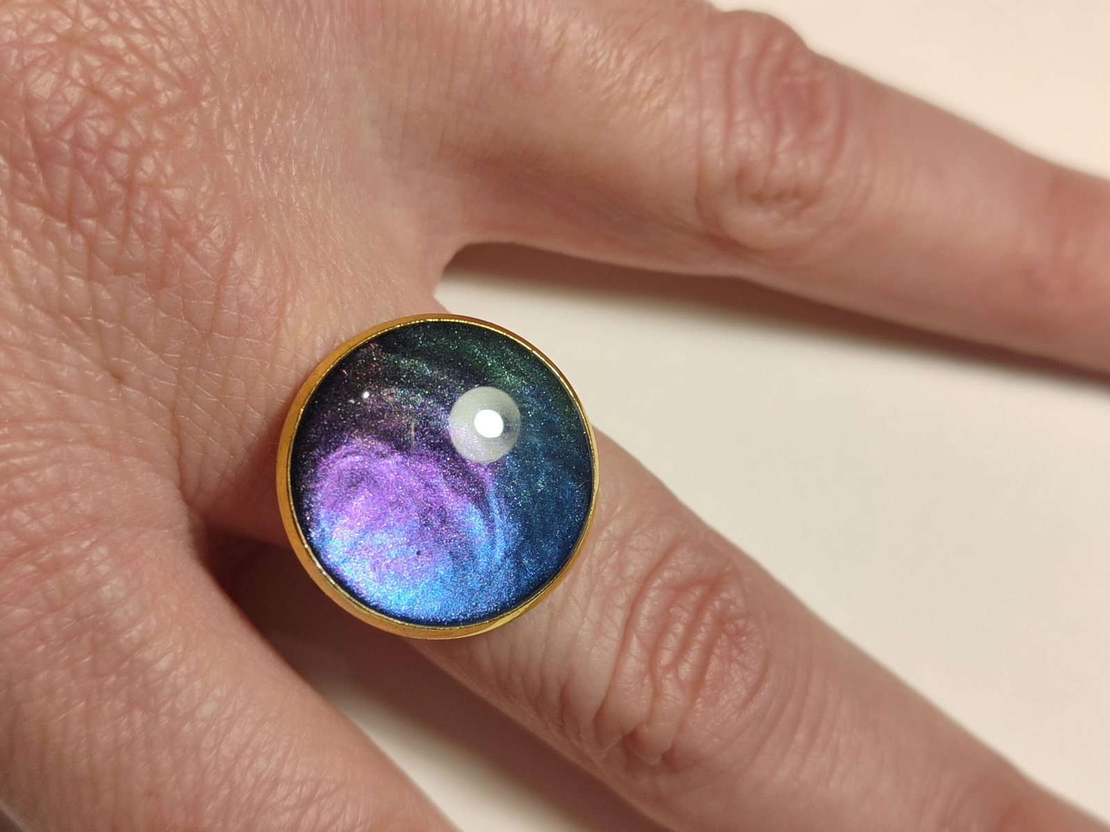 Anillo ajustable de acero inoxidable con POLVO IRIDISCENTE encapsulado en resina.