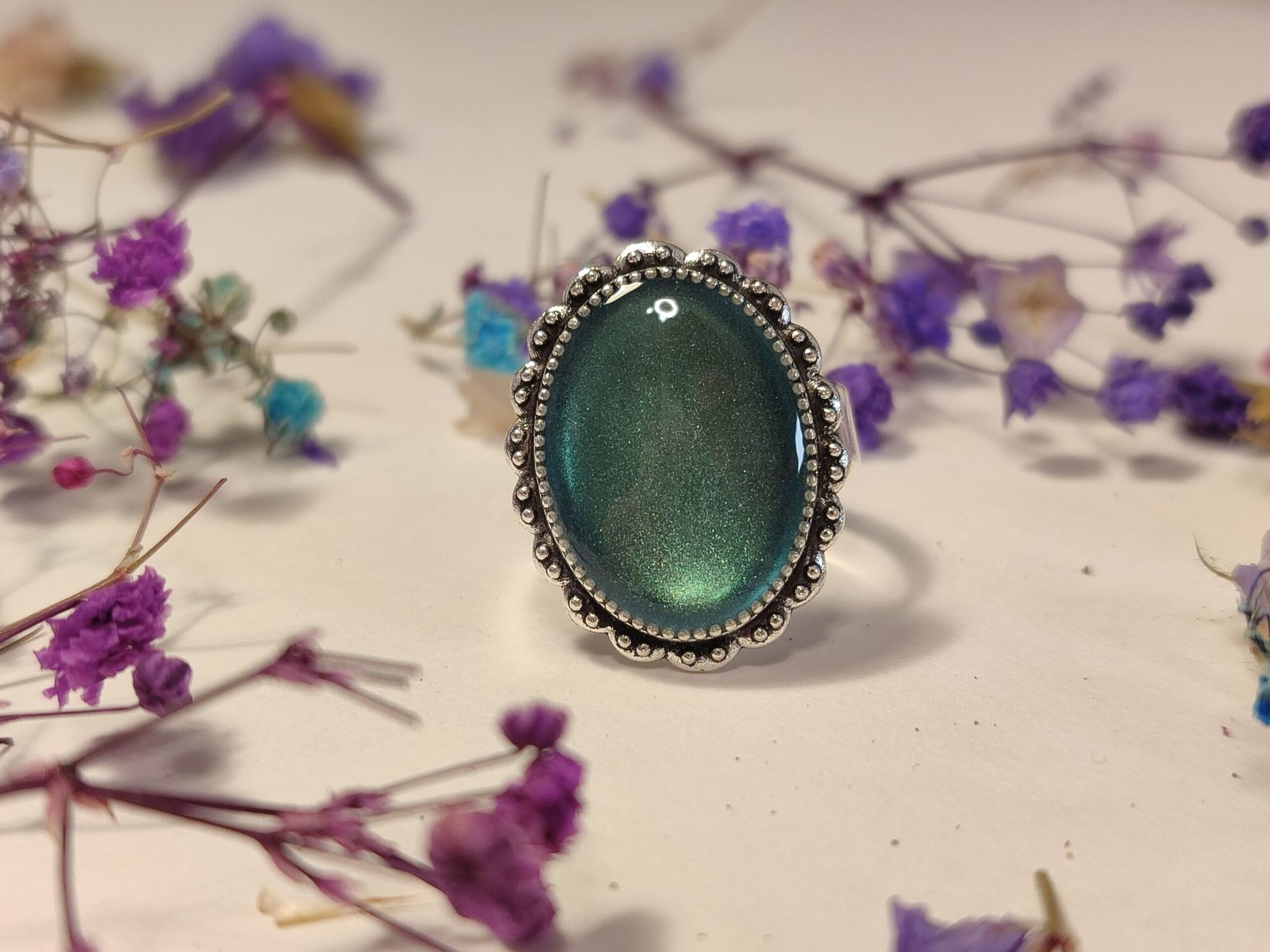 Anillo ajustable de acero inoxidable con POLVO IRIDISCENTE encapsulado en resina.