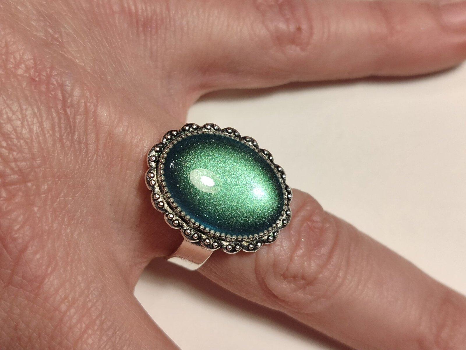 Anillo ajustable de acero inoxidable con POLVO IRIDISCENTE encapsulado en resina.