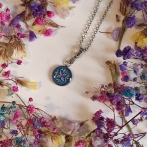 Colgante de acero inoxidable CON MOTIVO DE UNA BALDOSA (pegatina) encapsulada en resina.