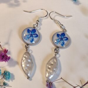 Pendientes con UNA FLOR AZUL (PEGATINA) encapsulada en resina y una piedra TIPO PERLA.