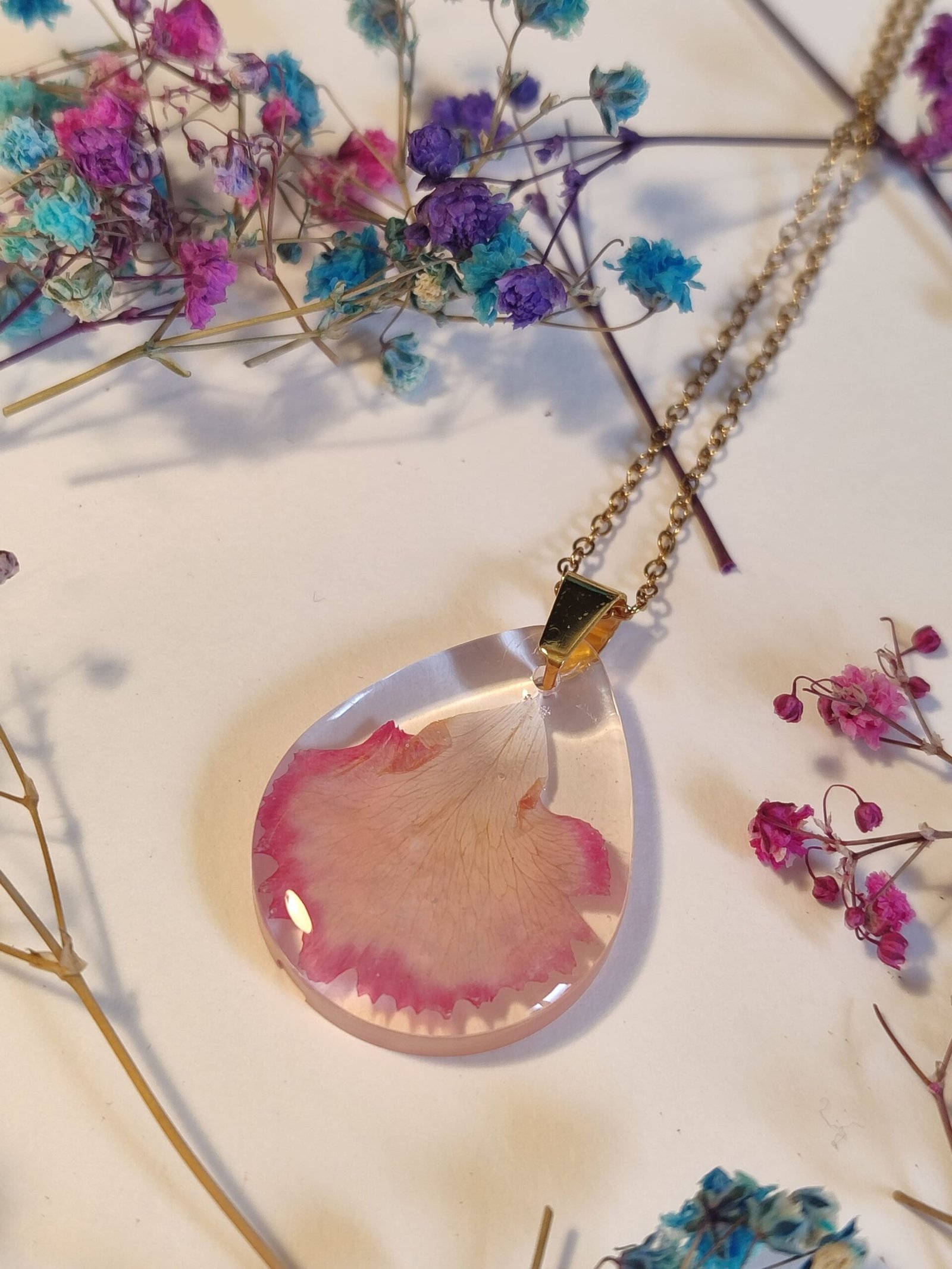 COLGANTE con UN PÉTALO DE CLAVEL encapsulado en resina.