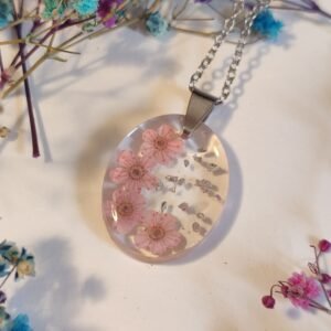 COLGANTE con UNAS FLORECILLAS MINI DE COLOR ROSA encapsuladas en resina.