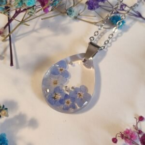 COLGANTE con UNAS FLORES DE NO ME OLVIDES encapsuladas en resina.