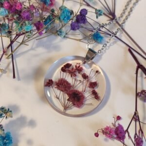 COLGANTE con UNAS FLORES DE PANICULATA encapsuladas en resina.