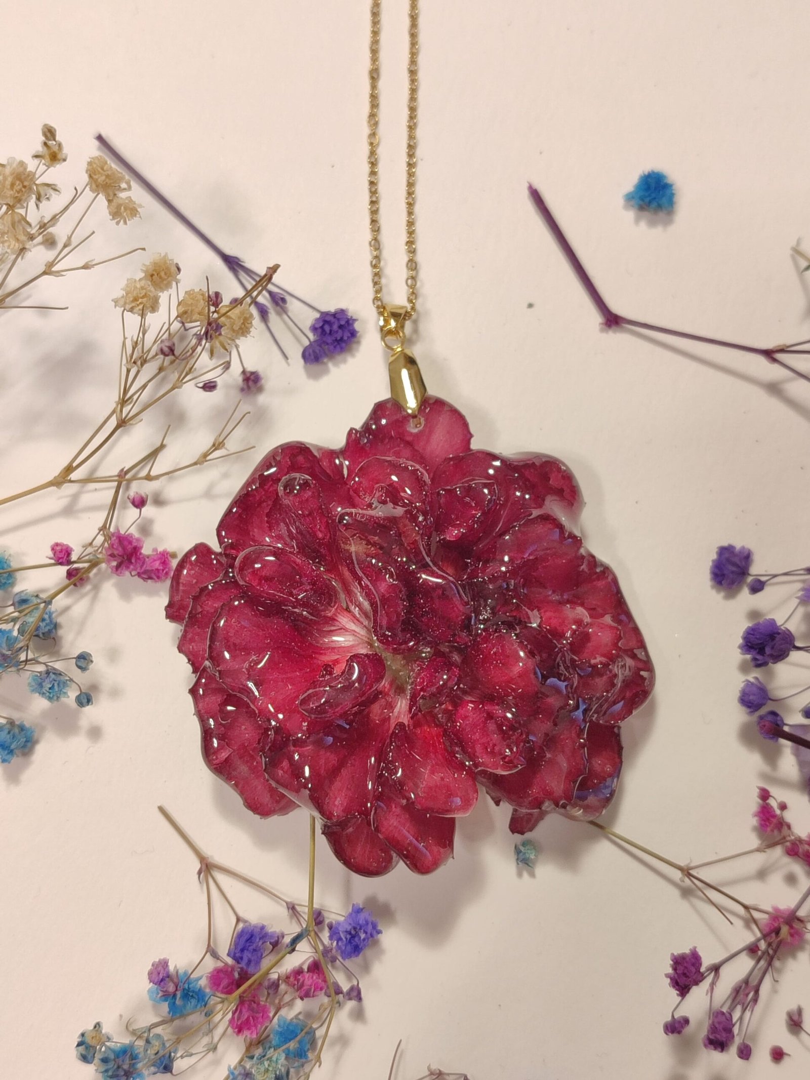 COLGANTE con UN CLAVEL COMPLETO encapsulado en resina.