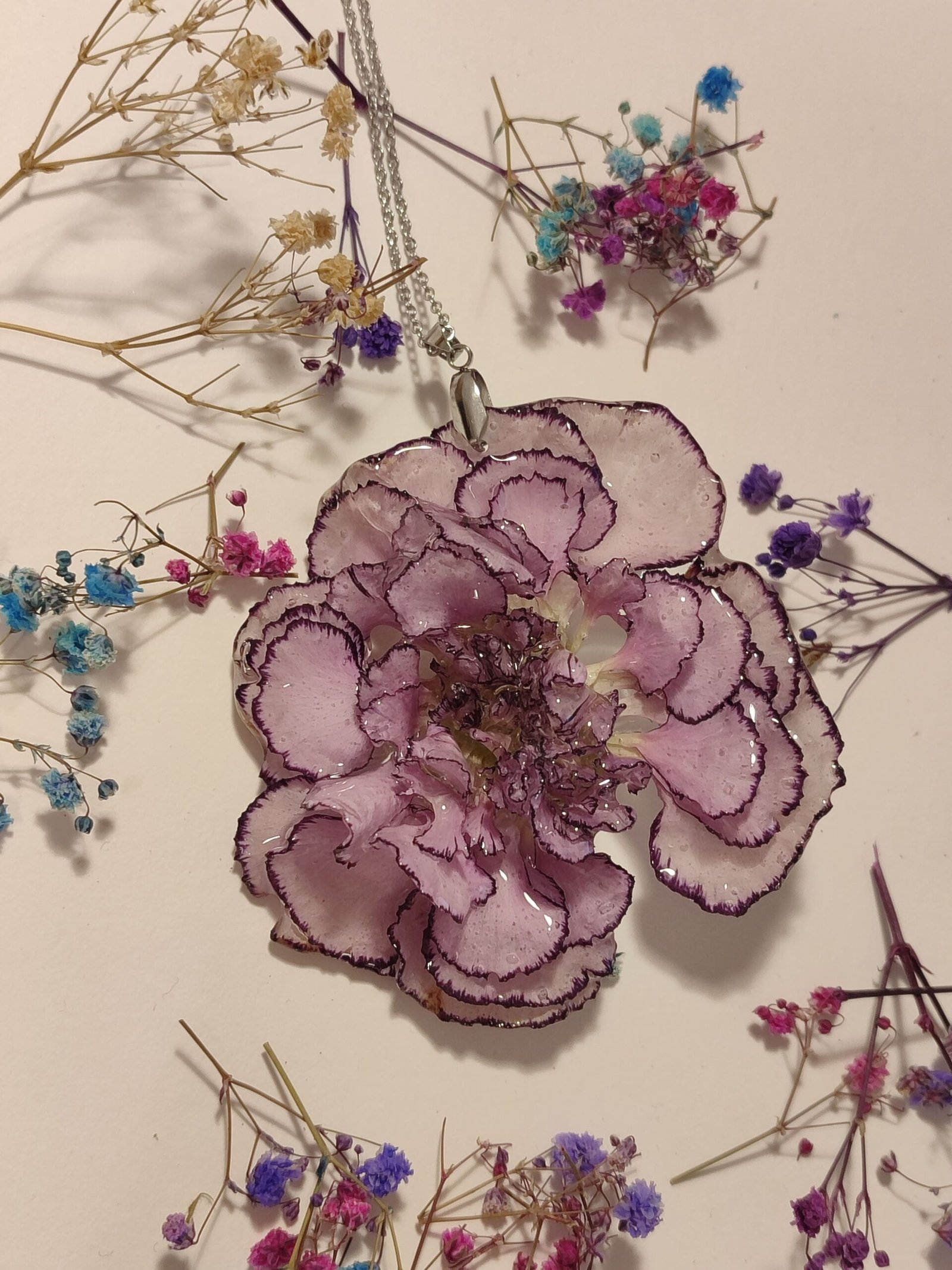 COLGANTE con UN CLAVEL BICOLOR COMPLETO encapsulado en resina.