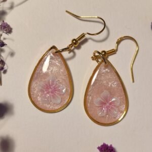 PENDIENTES con una FLOR BLANCA (pegatina) SOBRE FONDO ROSA NACARADO y encapsulada en resina.