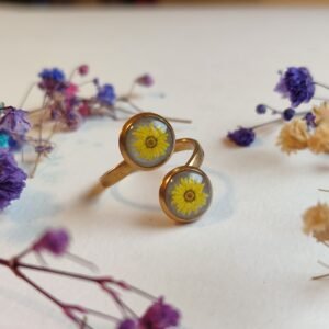 ANILLO con unas MARGARITAS (pegatinas) SOBRE FONDO NACARADO y encapsulada en resina.