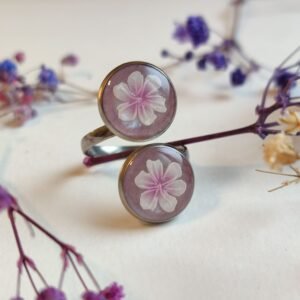 ANILLO con unas FLORES BLANCAS (pegatinas) SOBRE FONDO NACARADO y encapsuladas en resina.