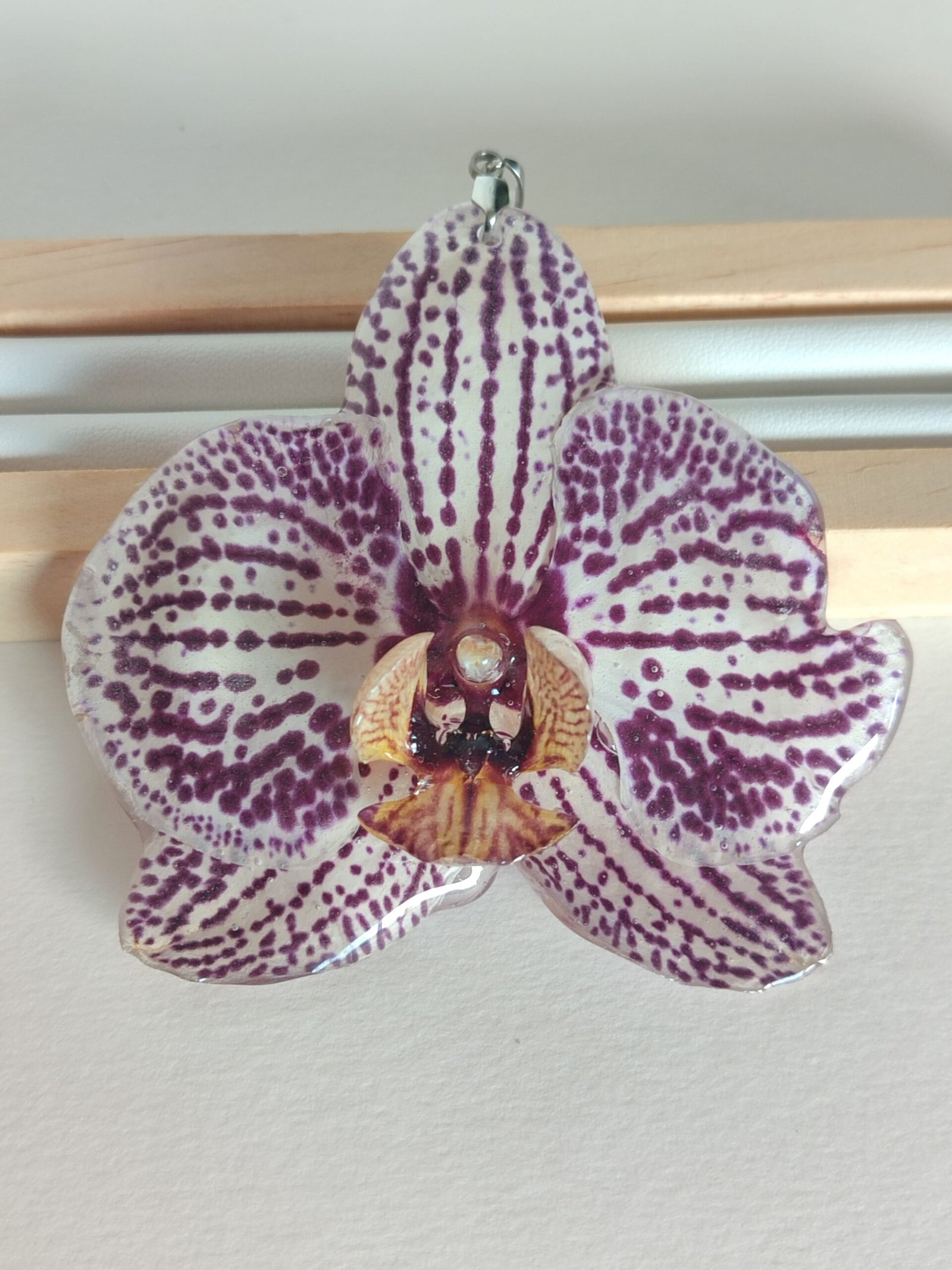 Colgante con UNA FLOR REAL DE ORQUÍDEA encapsulada en resina.