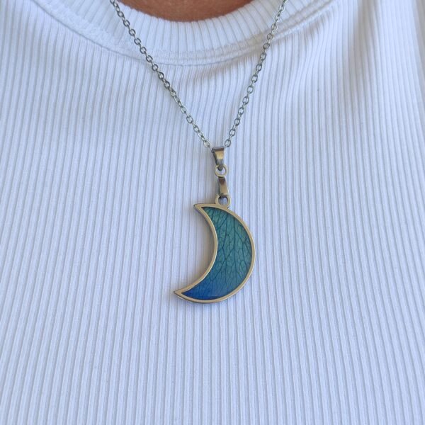 Colgante en forma de LUNA con un pétalo de ROSA AZUL encapsulado en resina