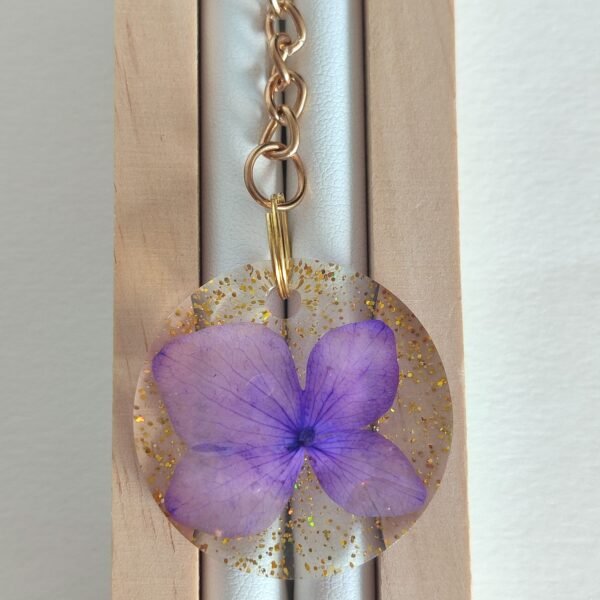 Llavero con una FLOR DE HORTENSIA LILA real encapsulada en resina