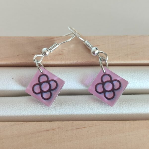 Pendientes con una pieza con el motivo DEL PANOT DE BARCELONA sobre fondo rosa