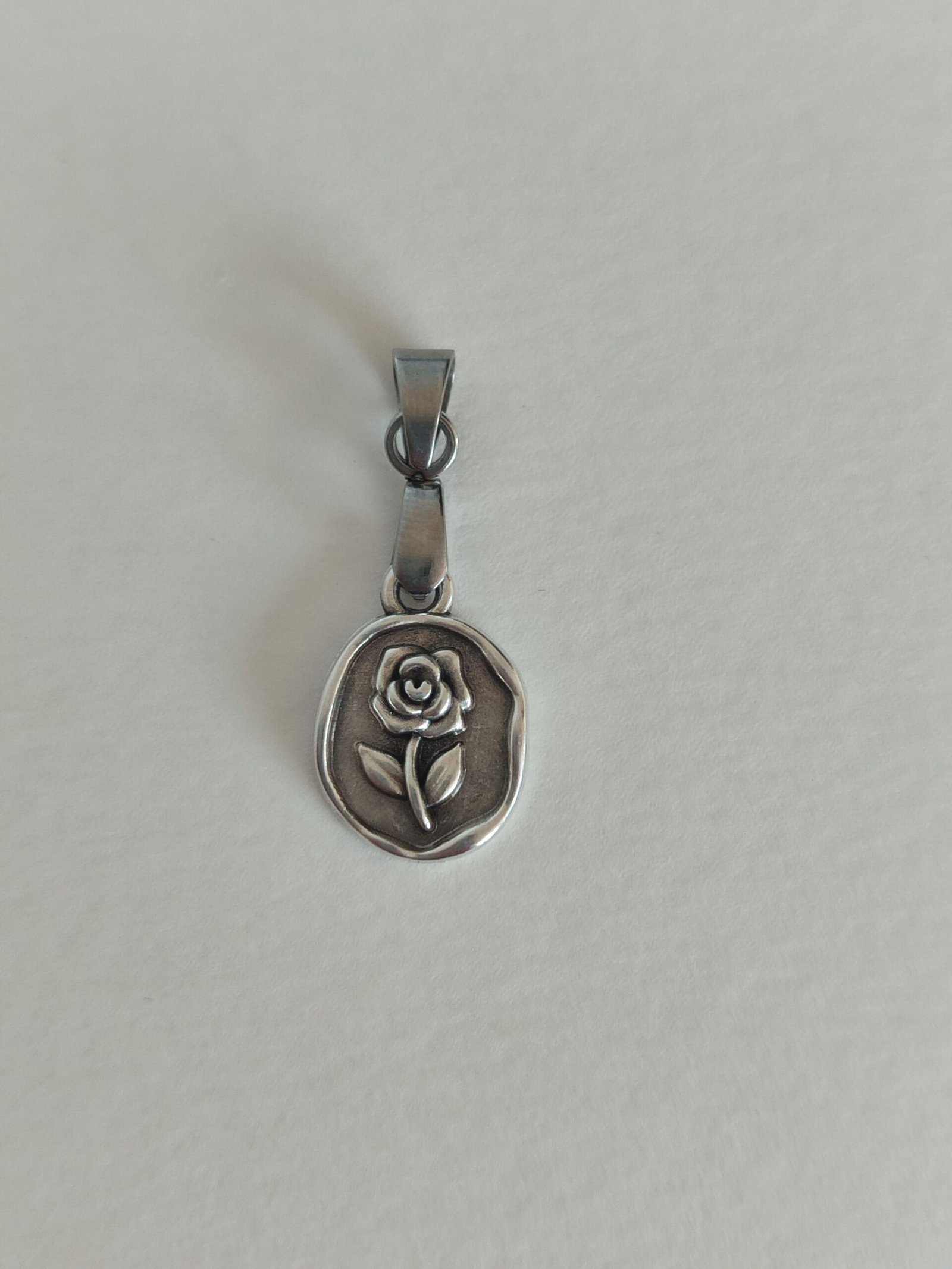 Colgante con una pieza tipo medallita con un diseño de una ROSA