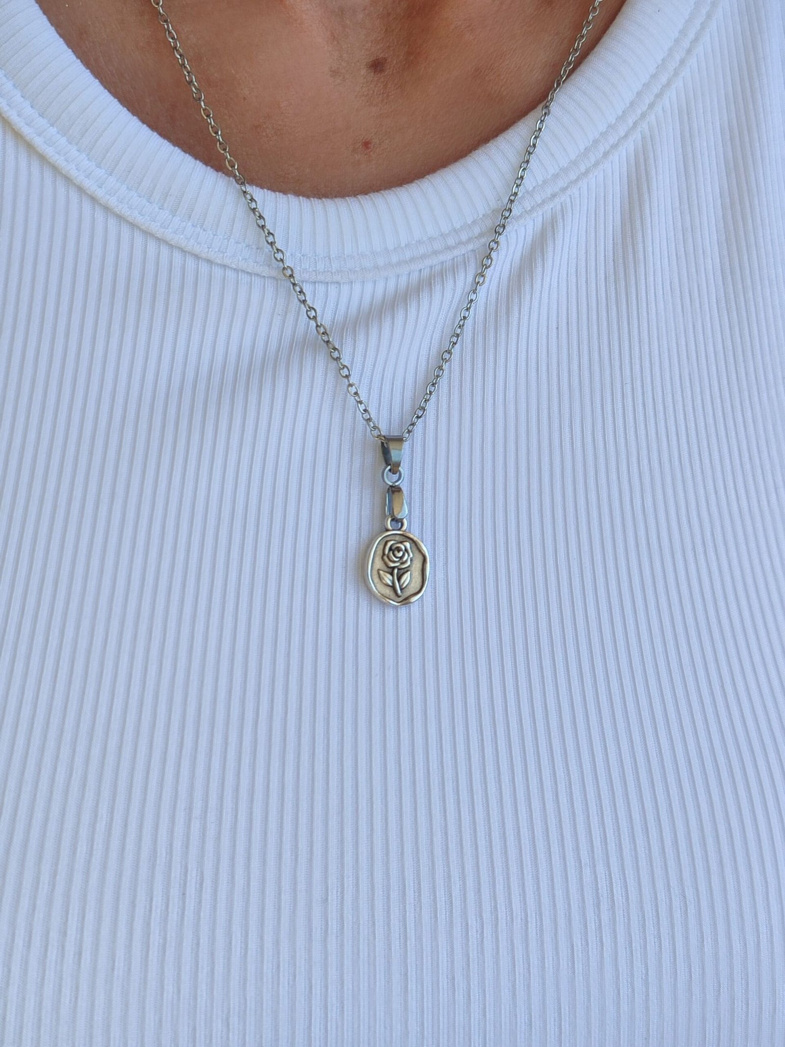 Colgante con una pieza tipo medallita con un diseño de una ROSA