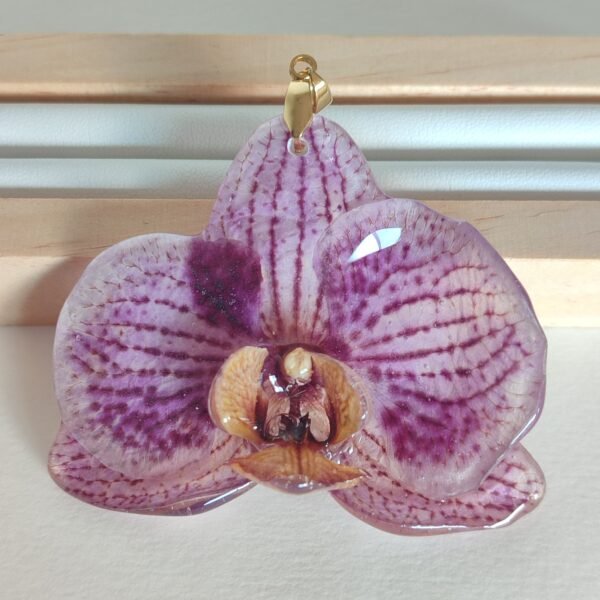 Colgante con una FLOR DE ORQUÍDEA LILA encapsulada en resina